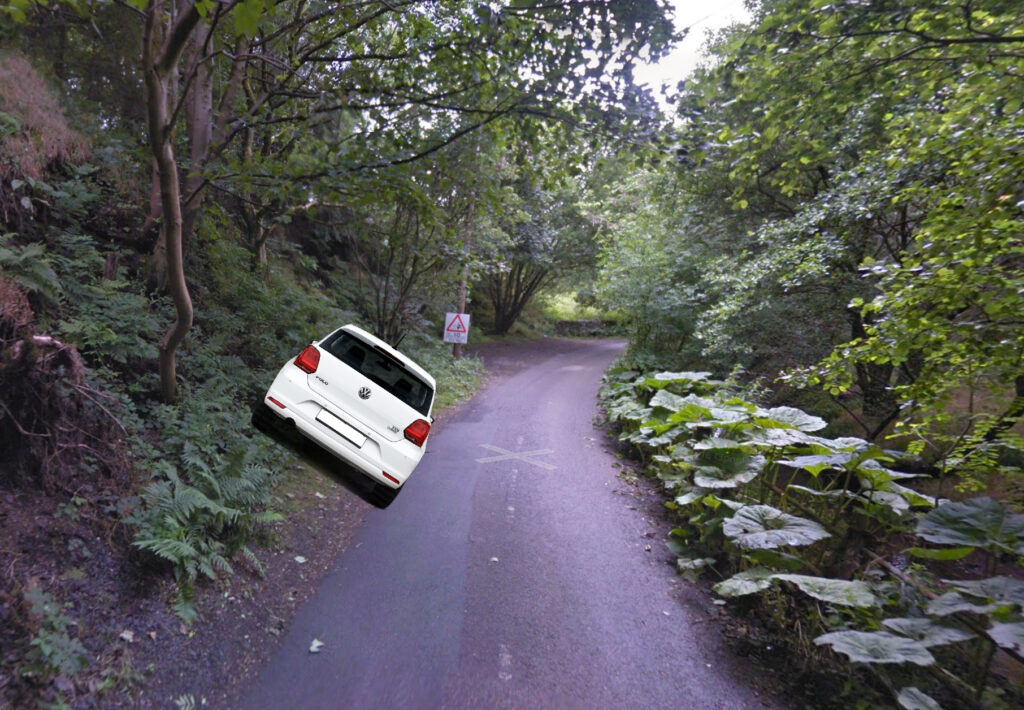 Screenshot of the parking space in Edale from Google StreetView with a superimposed VW Polo at a 45 degree angle, perched on a muddy verge.