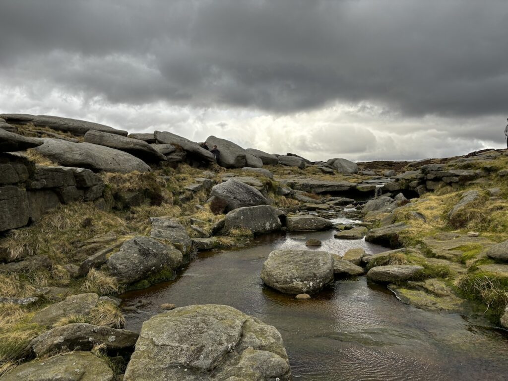 rainclouds rolling in as we cross the stepping stones on Kinder Scout